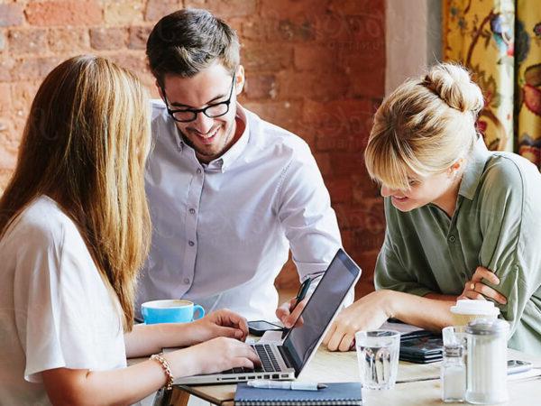 Two women and a man working on a project together